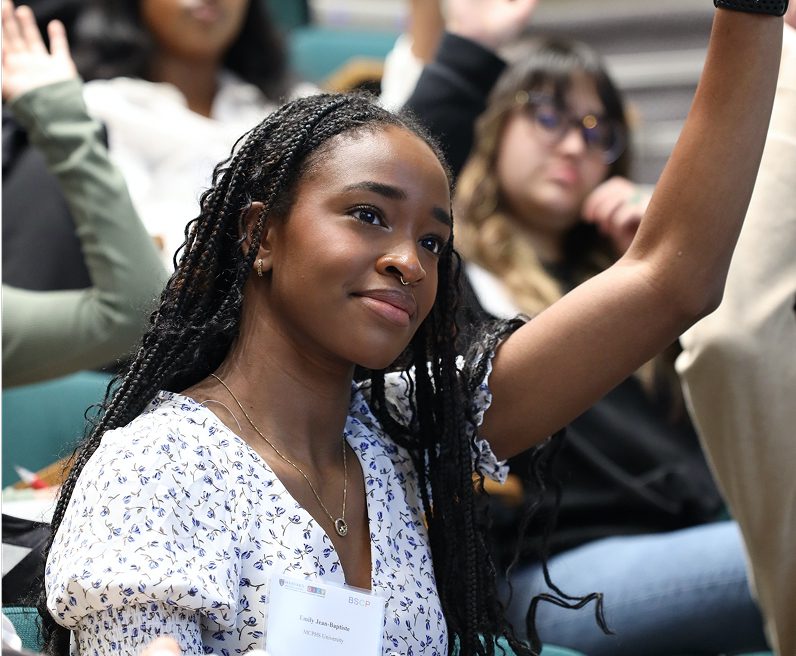 young woman with her hand raised