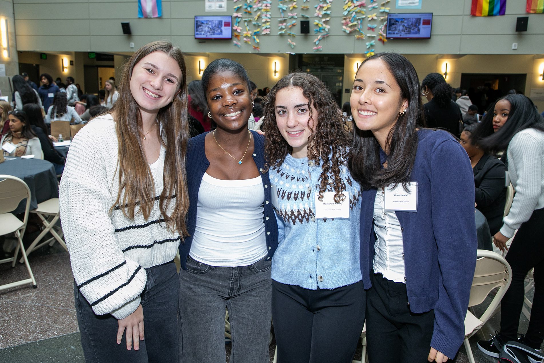 four students arm and arm smiling at camera