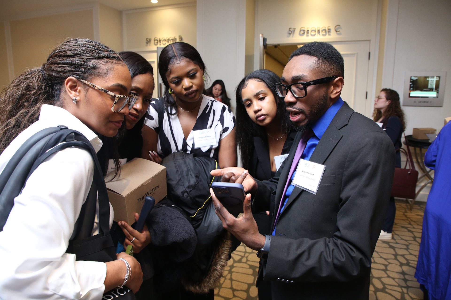 group of students gathering around looking at someone's phone