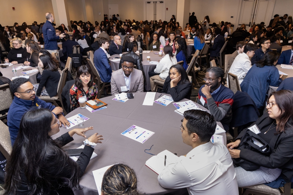student conference, students at round tables talking