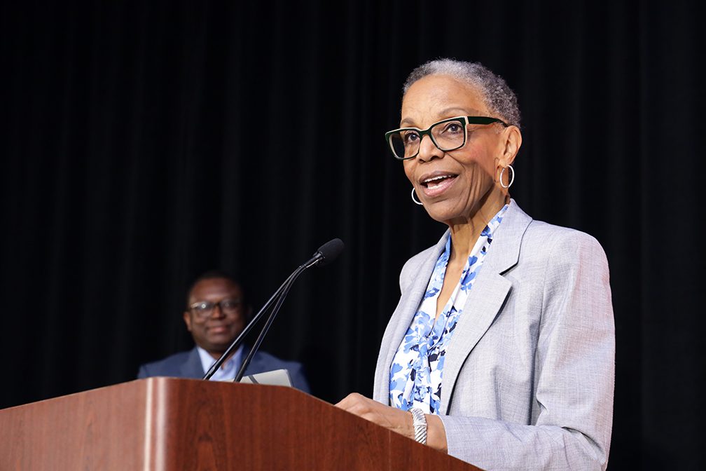 Dr Joan Reede spearking in front of podium