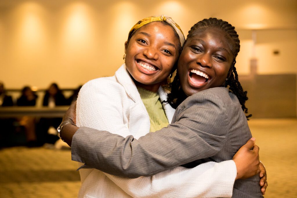 student student with arms around each other smiling for camera