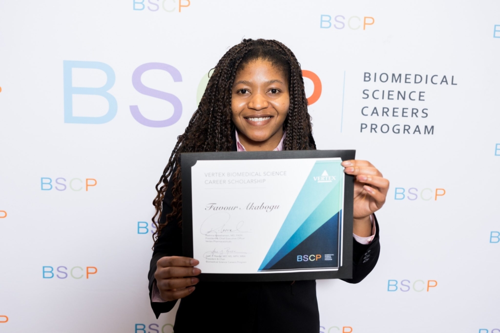 woman standing front of bscp step and repeat holding award