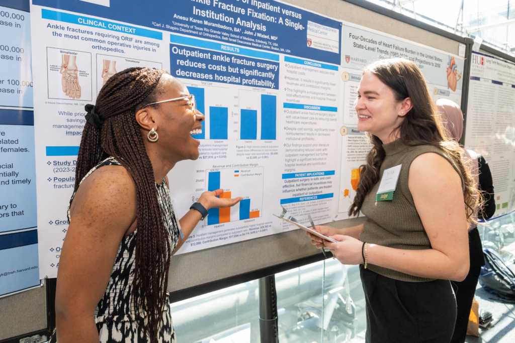 student standing with poster presentation showing research to judge