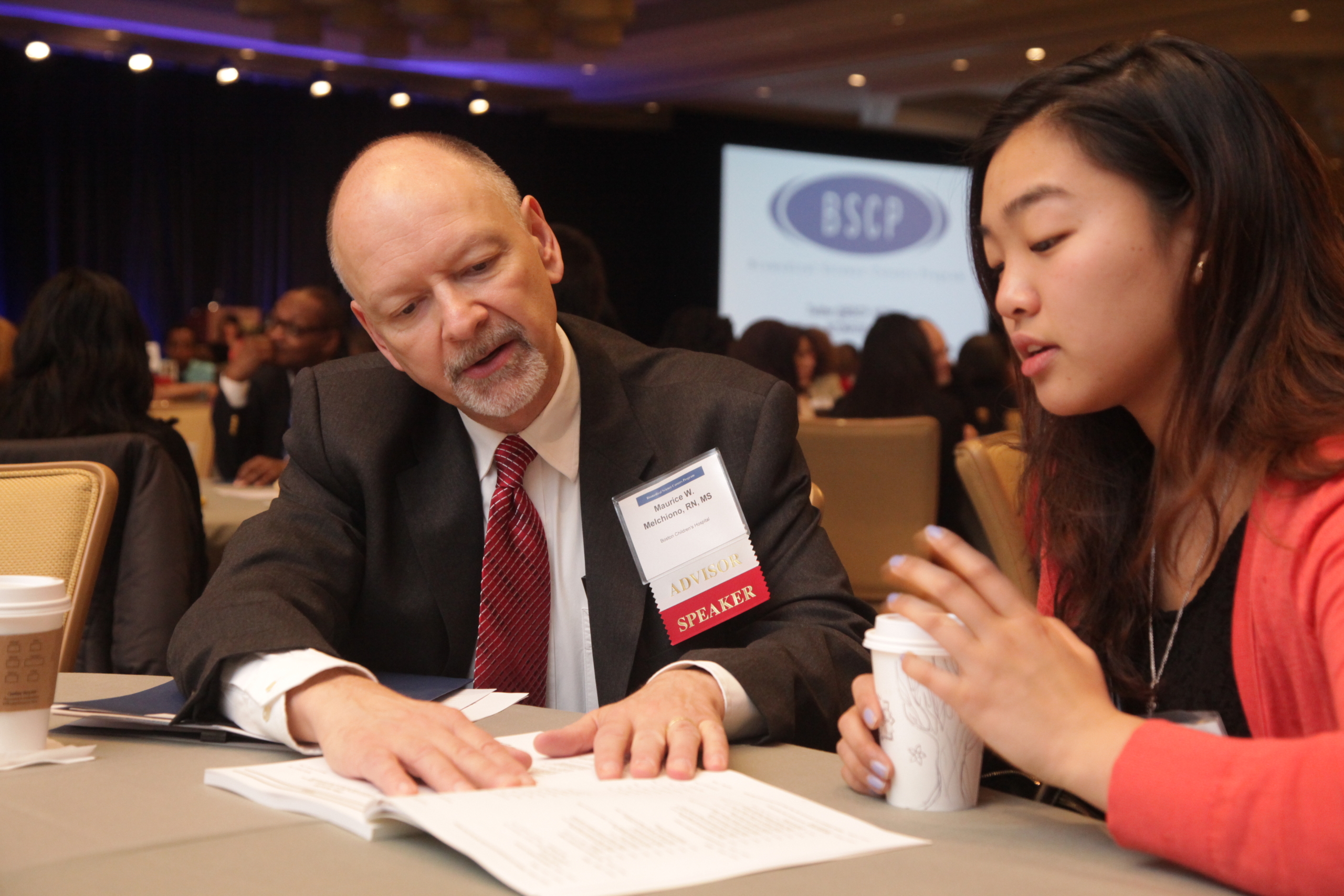 student meets with advisor while seated at table